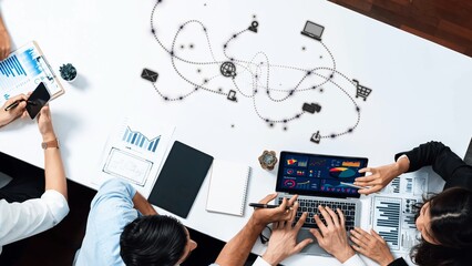 A modern office meeting showcases a diverse team collaborating on data analytics strategy using technology. Engaging discussions surrounded by charts and graphs. Raster