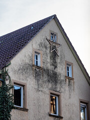 Obraz premium Weihnachtsstern an einer feuchten und stark verschmutzten Fassade