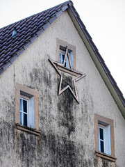 Weihnachtsstern an einer feuchten und stark verschmutzten Fassade