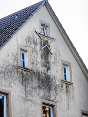Weihnachtsstern an einer feuchten und stark verschmutzten Fassade