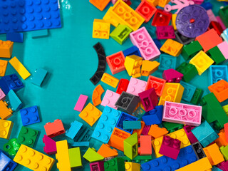 Fototapeta premium Colorful building blocks scattered on blue surface