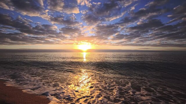 Golden Sunrise With Long Reflection and Gentle Waves in Spain