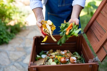 Man Composting Food Waste in Backyard Compost Bin for Sustainable Living