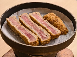 A Japanese beef cutlet dish, gyukatsu, made from sliced beef coated with panko breadcrumbs and served on a personal hot stone stove
