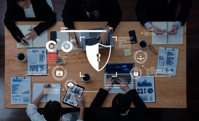 A diverse team collaborates in a modern office, reviewing data charts and discussing cybersecurity strategies while surrounded by technology and coffee. Trope