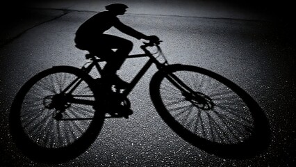 Silhouette of a cyclist on a bicycle against a dark, textured background, capturing the essence of outdoor activity and athletic pursuit