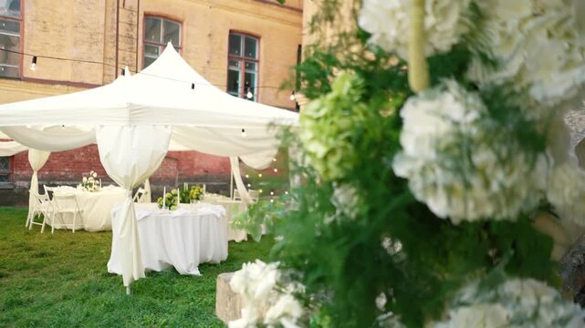 A beautiful wedding arch with white flowers and festive decor in an old Italian courtyard with architectural features. A symbol of romance and love on the bride and groom's special day