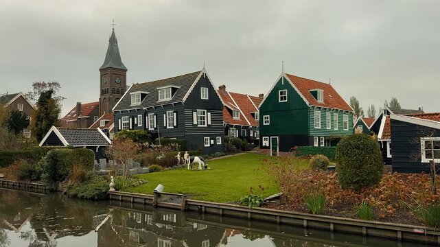 Panoramic view of Marken, Netherlands, featuring traditional green wooden houses, a classic white drawbridge, and a calm canal reflecting the overcast sky during a cloudy day.

