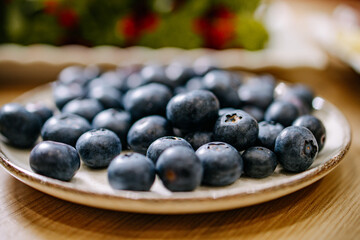 Minimal close-up of fresh blueberries on a ceramic plate. Soft natural light, shallow focus, and calm tones create a clean, healthy, and organic food aesthetic.