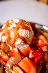 Macro dessert shot featuring vanilla ice cream, caramel sauce, and strawberries on a waffle. Rich textures, glossy details, and warm tones create a premium, indulgent food aesthetic
