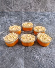 opped with creamy sauce and white chocolate cubes. Homemade dessert prepared for sale, sweet food background with shallow depth of field.