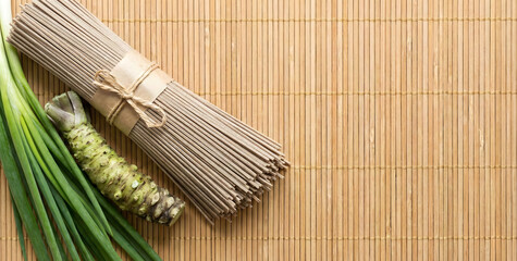 Fresh Wasabi root and traditional shark skin grater (Oroshigane) on a wooden table.