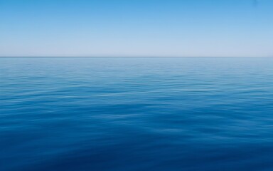 Obraz premium Calm Blue Ocean with Clear Sky Minimalist Seascape Background,Peaceful Open Sea and Blue Sky Horizon Nature Landscape,Blue Sea and Sky Background,Serene Blue Ocean Horizon with Natural Sky