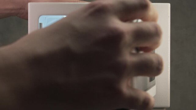 Close up shot shows man placing several bundles of one hundred dollar banknotes into safe compartment before closing door.