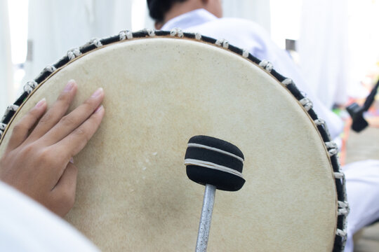 Traditional Hand Drum Performance: A Close-Up of a Tambourine Played in Indonesian Cultural Celebration