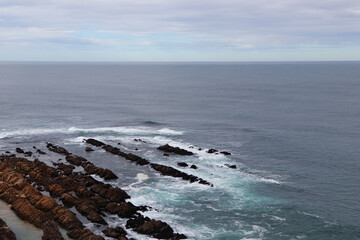Mossel Bay Point Rocks On Calm Overcast Day Pointing Towards An Open Ocean Horizon, South Africa