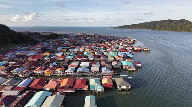 Stilted homes of the Bajau Laut rise gently above turquoise waters, where sea nomads have lived in harmony with the ocean for generations