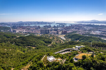 Obraz premium Aerial View of City and Lush Green Hills