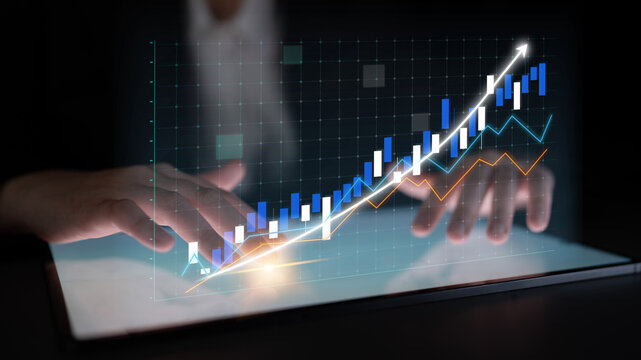A business professional engages with financial data on a tablet, featuring dynamic graphs that represent growth trends and market analysis in a modern digital setting. Impute - Powered by Adobe