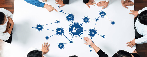 A diverse team collaborates on a marketing strategy, using visual data representations to drive decision-making. Hands point and engage in a dynamic brainstorming session. Amity