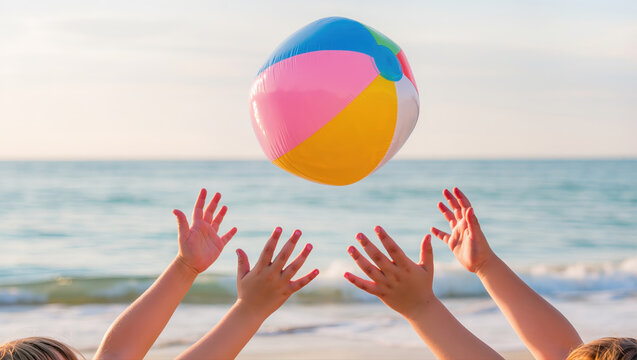 Children's hands reaching for a colorful beach ball in the air at seaside on a sunny day. Joyful summer game by the ocean. Pure fun moment.