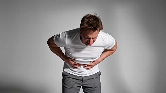Man Experiencing Severe Stomach Pain and Discomfort in Studio Setting