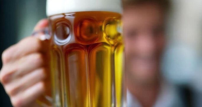 Man holding beer mug smiling closeup