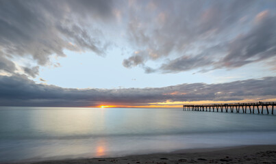 Sunset with dramatic clouds in sky over the Gulf of America formerlly the Gulf of Mexico at the Venice Fishing Pier in Venice Florida USA