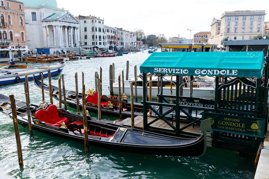 Venice, Italy - December 05, 2025: Gondolas docked at Servizio Gondole in Venice, showcasing iconic architecture and vibrant canal scenery, perfect for travel and tourism imagery