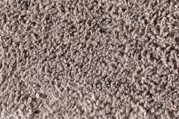 Textured background of gray carpet speckled with short-pile strands