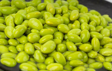 Edamame beans bowl textured background. Green soy bean pattern, many cooked young soybeans