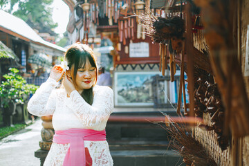 Balinese Woman Adjusting Frangipani Flower Hair Accessories