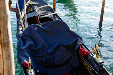 Obraz premium Venice, Italy - December 05, 2025: Gondola with blue cover resting on serene water in Venice, showcasing traditional craftsmanship and iconic Italian culture with reflections