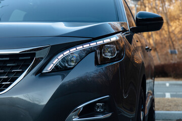A gray car showcases an alluring headlight design and elegant front grill.