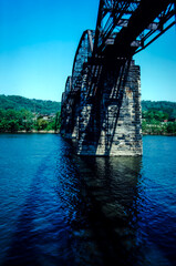 Underside view of a rail trestle bridge over a river in West Virginnia
