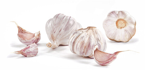 Kilka gł&oacute;wek czosnku i kilka ząbk&oacute;w luzem na białym tle