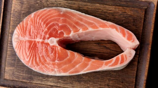 Fish, raw salmon steak, fresh seafood for grilling with salt, spices, and herbs. Raw salmon steak as a food background for your design.
