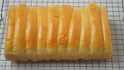 Freshly cooked golden brown comb bread is served on a cooling rack placed in a white place (isolated white).