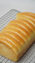 Freshly cooked golden brown comb bread is served on a cooling rack placed in a white place (isolated white).