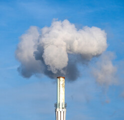 Wei&szlig;er Rauch steigt aus einem Industrieschornstein