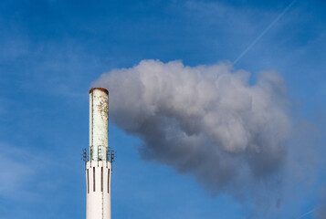 Wei&szlig;er Rauch steigt aus einem Industrieschornstein