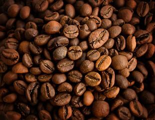 background of roasted brown coffee beans with darkened edges