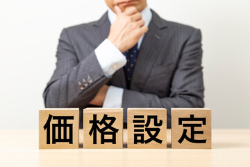 「価格設定」と書かれたブロックとビジネスマン