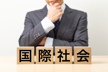 「国際社会」と書かれたブロックとビジネスマン