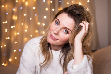 Fototapeta premium A young woman with Christmas balls at home preparing for Christmas