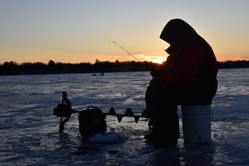 Ice fishing at sunset. 