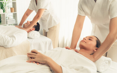 Obraz premium Caucasian couple customer enjoying relaxing anti-stress spa massage and pampering with beauty skin recreation leisure in day light ambient salon spa at luxury resort or hotel. Quiescent
