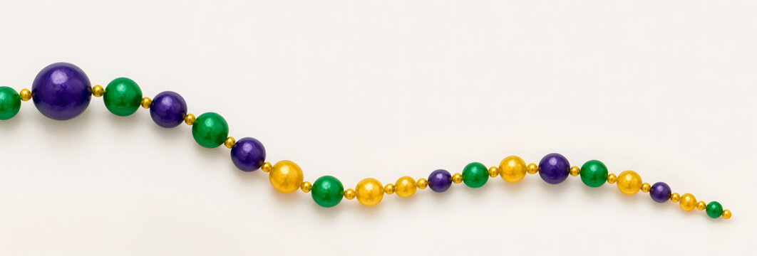 Single Mardi Gras bead necklace with mixed size beads in purple green and gold on white background