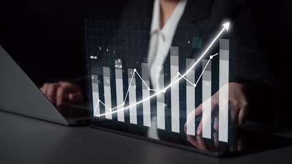 A business professional analyzes financial data on a laptop, with holographic graphics illustrating growth trends and vital statistics in a modern workspace. Copula - Powered by Adobe