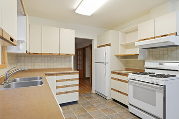 Clean and empty kitchen with white cabinets and a white stove